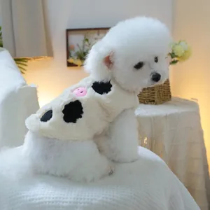 Dettaglio del gilet di peluche per animali con stampa mucca e naso di maiale ricamato
