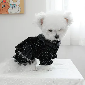 Détail d'une élégante robe noire en velours pour chien avec pois blancs et dentelle