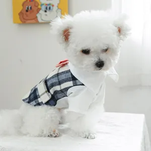 Detail of blue plaid pet tuxedo with white shirt and pink bow tie on a small dog