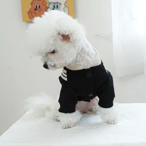 Detail of a black pet jacket with white striped sleeves and snap buttons on a dog