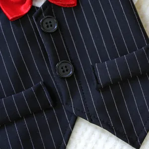 Detail of dog tuxedo vest featuring black stripes, red bow tie, and double buttons