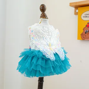 Macro detail of white lace pet dress with sequined butterfly and blue tutu layers