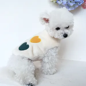 Dettaglio di un gilet in pile bianco per animali con ricamo a cuore su un cane piccolo