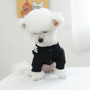 Detail of pet dog jacket featuring black fabric with white stripes and snap fasteners