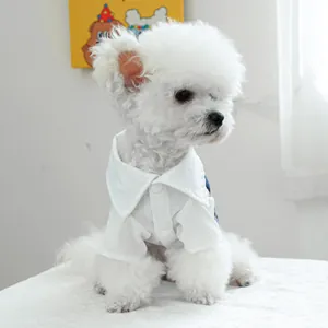 Detail of white pet shirt with buttons and blue denim fabric for small dogs