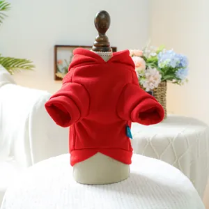 Détail du tissu en coton épais et de l'étiquette bleue sur un sweat rouge pour chien