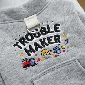 Detalle de sudadera gris para perro con anillo en D metálico y bordado en la tela