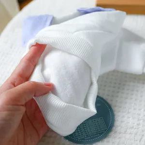 Detailed view of white fleece pet apparel with striped collar and size tag information