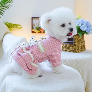 Dettaglio del vestito rosa a quadri per animali con fiocco a pois e pizzo dorato
