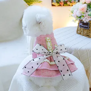 Dettaglio di un vestito rosa per animali a quadretti con pizzo e grande fiocco a pois