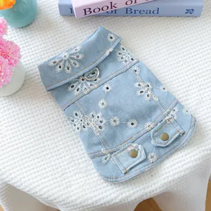 Detail of light blue denim pet vest with white daisy embroidery and metal D-ring attachment