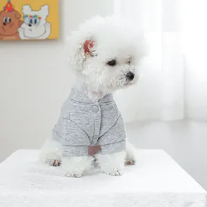 Detail eines grauen Haustier-Sweatshirts mit Druckknöpfen an einem Bichon Frisé
