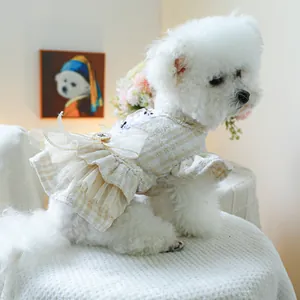 Dettaglio dell'abito per cani in tweed con fiocco in rete e volant in pizzo beige