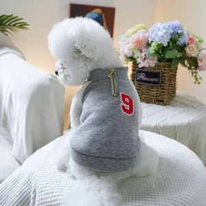 Détail d'un gilet gris pour chien avec le numéro 9 rouge et une fermeture éclair en métal
