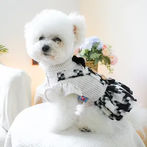 Dettaglio di un vestito per cani con corpetto a maglia, gonna a scacchi e bottoni a cuore