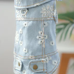Detail of light blue denim dog dress with floral embroidery and metal D-ring buckle