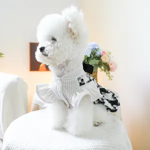 Dettaglio abito per animali con top in maglia crema, fiocco e gonna a quadri