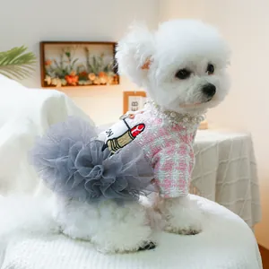 Detail von rosa Hundekleid mit Hahnentrittmuster, Perlenhalsband und Stickerei