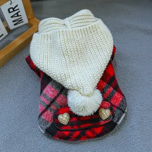 Detail of red plaid pet coat with knit pompom hood and heart-shaped metal buttons