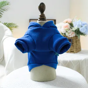 Détail d'un sweat à capuche bleu pour animaux sur un tabouret blanc, décor intérieur