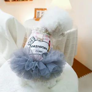 Detail eines rosa Tweed-Hundekleids mit Perlenkragen, Kamelien-Print und grauem Tüllrock
