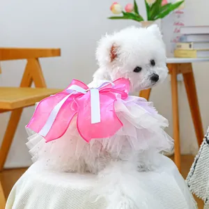 Detail of multi-layered pink tulle pet dress with large bow on a white bichon dog
