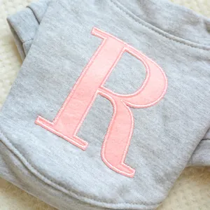 Detalle de la letra R rosa bordada en una sudadera gris de algodón para perros y gatos