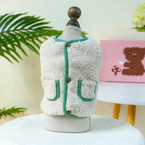 Detail of warm cream fleece pet vest with green trim and cozy lamb wool texture