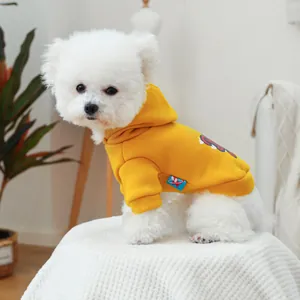 Détail du sweat à capuche jaune pour chien avec graphisme rouge et étiquette tissée bleue