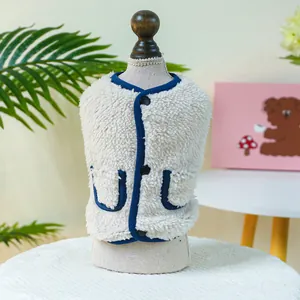 Close-up of warm cream sherpa pet vest with blue trim and button closure detail