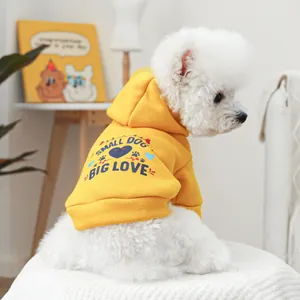 Gros plan d'un chien blanc en sweat jaune avec imprimé Small Dog Big Love et cœurs