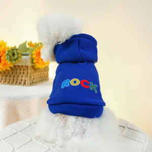 Sweat à capuche bleu pour chien avec imprimé ROCK coloré sur un petit chien blanc à la maison