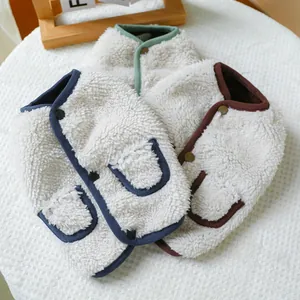 Close-up of warm fleece pet vests in blue, green and brown with soft texture and buttons