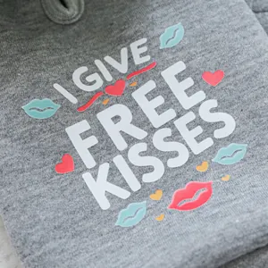Detail of grey pet hoodie fabric with I GIVE FREE KISSES text and colorful lip prints
