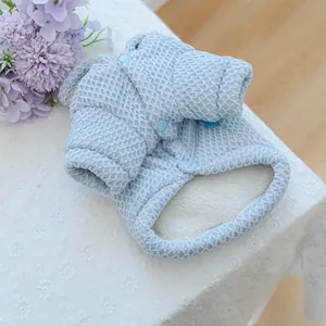 Detail of light blue quilted pet coat showing thick white fleece lining and snap buttons