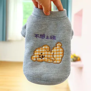 Detalle de sudadera gris para mascotas con bordado de perro a cuadros y texto bordado