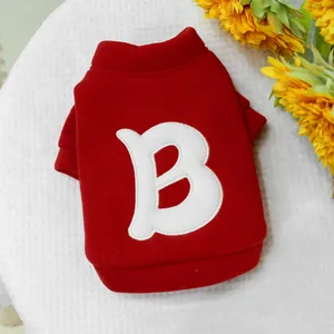 Detalle de sudadera roja para mascota con parche de letra B blanca en tejido algodón