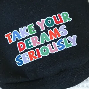 Detailaufnahme eines Hunde-Hoodies aus Baumwolle mit buntem DERAMS Siebdruck-Design