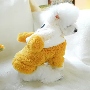 Soft yellow and white plush dog sweater with pom-pom details on a white Bichon Frise