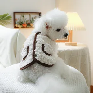 White fleece pet vest with brown trim and snap button detail worn by a small dog