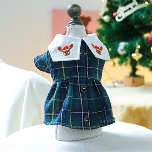 Detail of pet Christmas dress with reindeer embroidery and dark green plaid fabric