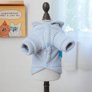 Detail of light blue quilted pet hoodie with soft texture and 3-button closure