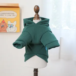 Detail of dark green pet hoodie with warm knit fabric on a wooden mannequin stand