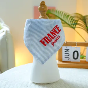 Detail of blue striped pet bandana with France Paris print on a white display model