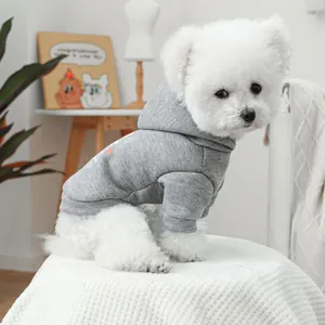 Gray pet hoodie with heart patterns on a cozy white rug in a bright home setting