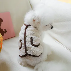 Detail of warm sherpa pet vest with three buttons and brown trim on a white puppy