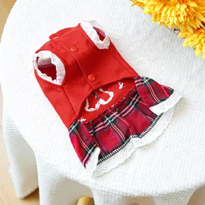 Detail of red festive pet dress with lace edges and heart pattern on white background