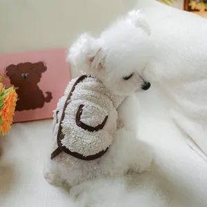 Detail of warm sherpa fleece pet vest on a white dog, featuring cozy brown trim and pockets