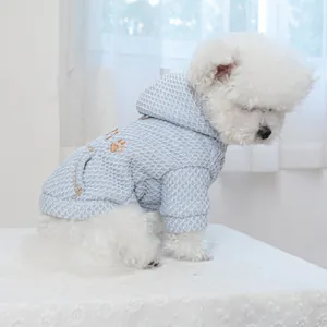 Detail of light blue waffle-knit pet hoodie showing textured fabric on a white puppy