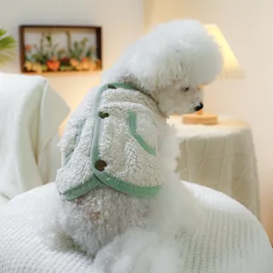 Side view of white poodle wearing a warm fleece pet vest with green trim and brown buttons
